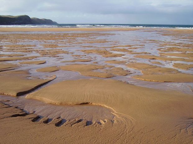 Strathy Bay. Extensive sands with crags stretching out to Strathy Point.