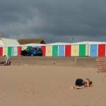 Colourful beach huts against a black sky